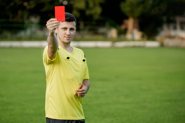 Referee showing a red card to a displeased football or soccer player while gaming. Concept of sport, rules violation, controversial issues, obstacles overcoming