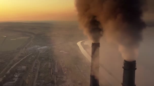 Vista aérea de tubulações altas da usina de carvão com fumaça preta que se move acima da atmosfera poluente no por do sol. — Vídeo de Stock
