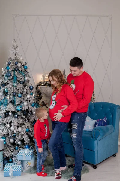 Família feliz de três, jovem mãe esperando um novo bebê, pai e seu filho perto da árvore de Natal decorada — Fotografia de Stock