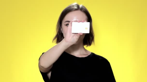 Leende Ung Kvinna Med Kreditkort Gul Bakgrund — Stockvideo