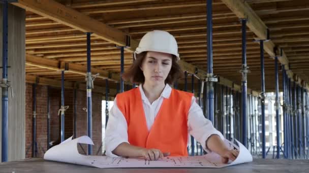 Arquitecto o ingeniero de trabajo, proyecto de construcción de navegación interior del sitio de construcción con plano. Mujeres ingenieros de construcción o arquitectos trabajadores — Vídeos de Stock