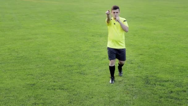 Fotbalový rozhodčí ukazující penaltu, žlutou a červenou kartu, odstraní hráče. Pojetí sportu, porušení pravidel, ofsajd