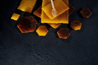 Kavanozda bal ve bal peteği. Siyah tahta bir arka planda. Metin için boş alan. Üst görünüm