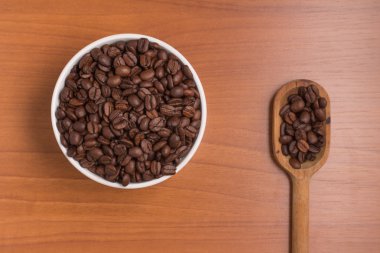 Kahve çekirdekleri bir kase ve kaşık içine. Coffea arabica