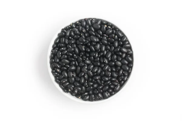 Schwarze Bohnen in eine Schüssel vor weißem Hintergrund geben. Phaseolus vulgaris — Stockfoto