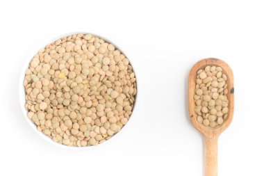 Bir kase ve beyaz zemin üzerine kaşık içine çiğ mercimek. (Lens cul