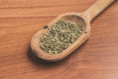 Ahşap bir masa üzerinde bir kaşık içine kuru kekik