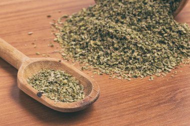 Ahşap bir masa üzerinde bir kaşık içine kuru kekik