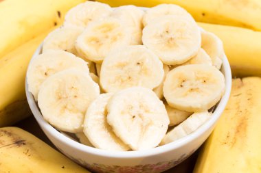 Bir kase içinde ahşap bir masa içine muz dilimleri