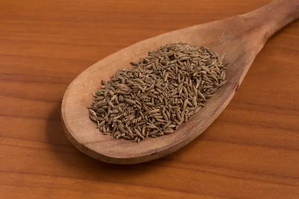 Coma sementes em uma colher — Fotografia de Stock