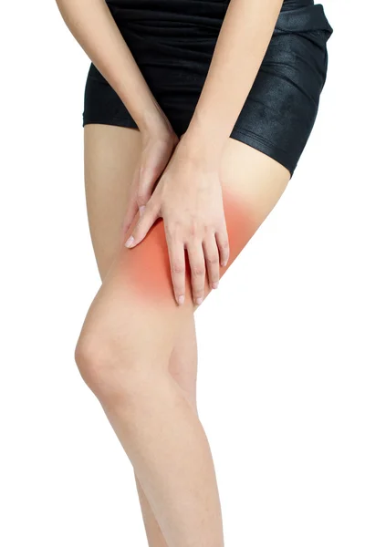 Mujer sosteniendo su muslo con dolor, con rojo resaltado en la zona del dolor sobre un fondo blanco — Foto de Stock