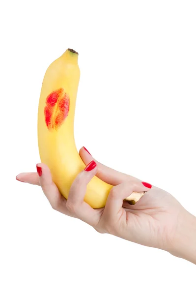 Sexy hand with red nails holding banana with red lipstick. — Stock Photo, Image