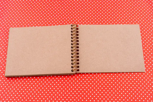 Spiral Notebook on a red dotted background — Stock Photo, Image