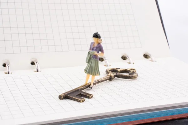 Figura perto de uma chave em um caderno — Fotografia de Stock