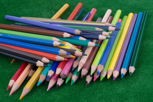 Crayons de couleur éparpillés sur l'herbe verte — Photo