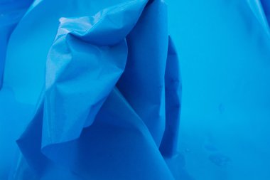 Kırışmış kağıt mavi arkaplanda suya konur.