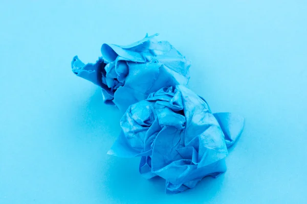 Papel arrugado puesto en agua en fondo azul —  Fotos de Stock