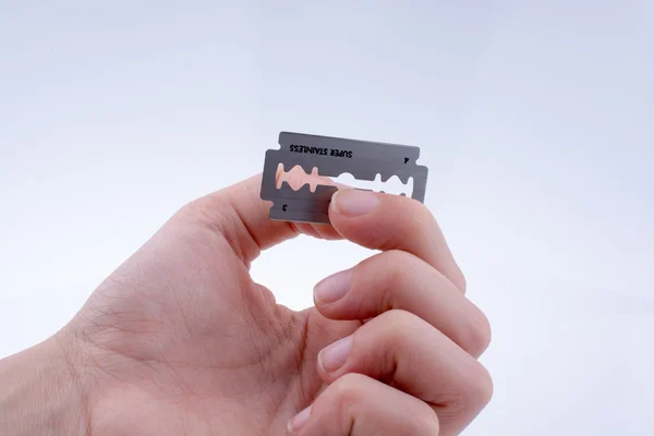 Bir tıraş bıçağı tutan el