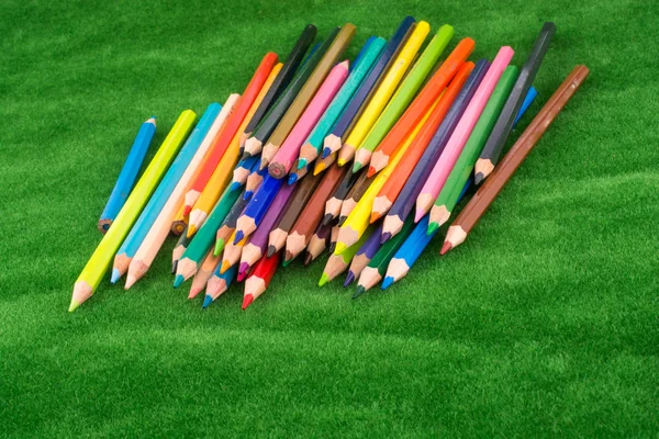 在绿色草地上的彩色铅笔 — 图库照片