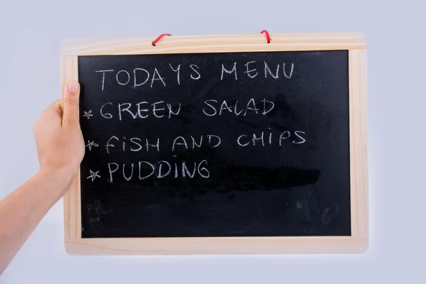 Mão segurando a prancha com o menu do dia — Fotografia de Stock