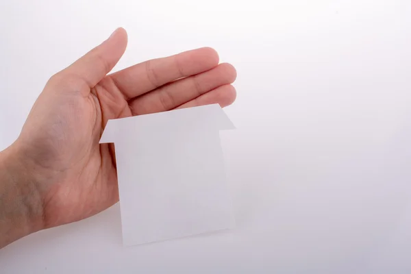 Hand som håller ett papper hus — Stockfoto