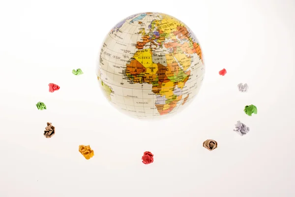 Crumpled papers form a round shape around a globe — Stock Photo, Image