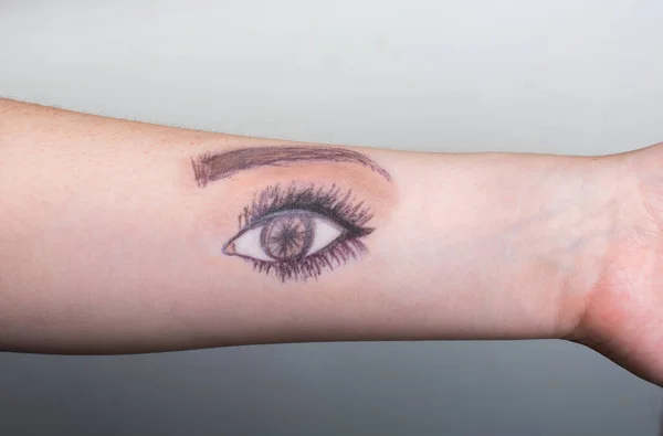 Single eye drawn on the arm of a teenager