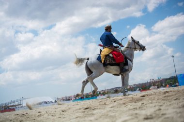 Osmanlı atlısı etnik kıyafetleriyle atına biniyor.