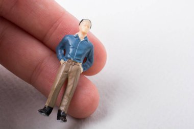 Elindeki minyatür insan figürü.