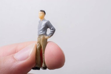 Elindeki minyatür insan figürü.