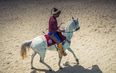 Osmanlı atlısı etnik kıyafetleriyle atına biniyor.
