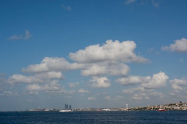 Beyaz renkli bulutlar gündüz vakti mavi gökyüzünü kaplar.