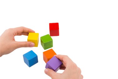 Renkli tahta bloklarla oynayan ve inşa eden eller. Erken öğrenme ve geliştirme