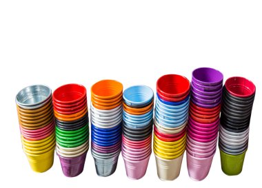 Çok renkli küçük metal kovalar tek tek istiflenir. Dekoratif kovalar beyaz arkaplanda izole edilmiş farklı renklerde.