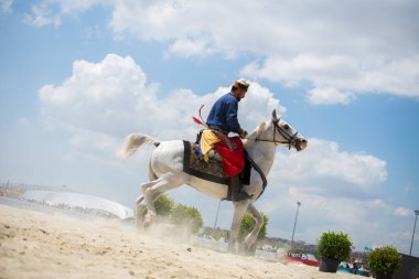 Atlı okçu at sırtında etnik kıyafetleriyle geziyor.