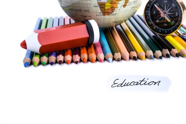 Lápices de colores con lápiz, globo, brújula y nota de educación — Foto de Stock