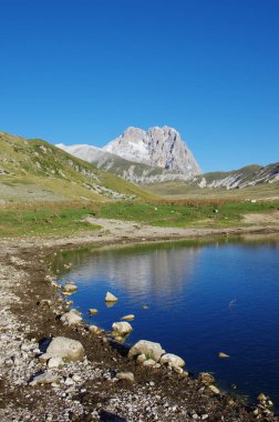 Corno Dağı 'nın zirvesi gökyüzüne doğru yükselir ve dağ gölüne, Gran Sasso' ya, Abruzzo 'ya, L' Aquila 'ya, İtalya' ya yansımaktadır.
