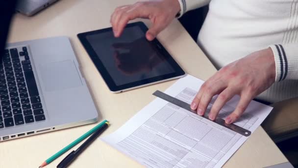 Hands typing on tablet financial information. — Stock Video