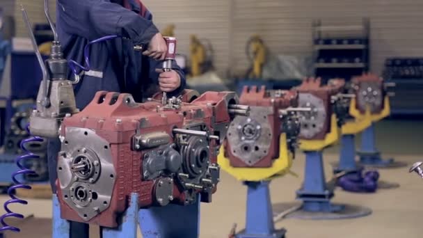 Worker tight nuts on motor, engine by automatic screwdriver. — Stock Video