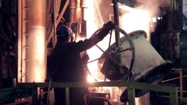 Çelik fabrikası işçisi erimiş metal ile çalışır.