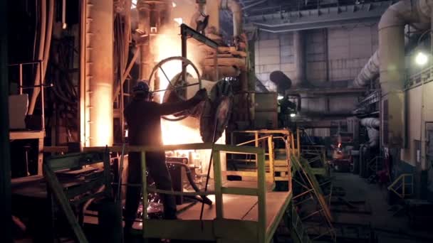 Worker on steel plant operates with  molten metal. — Stock Video