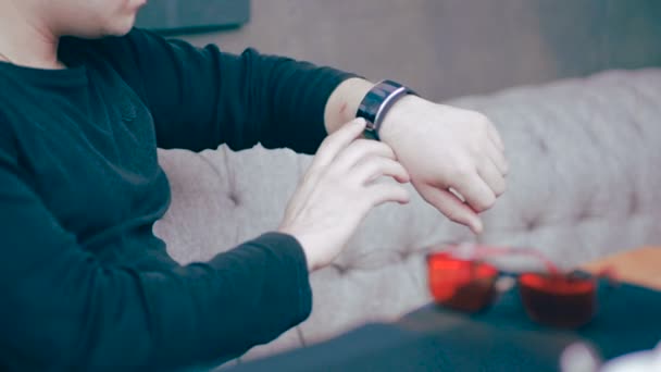 Ung affärsman med smartwatch sitter i café. — Stockvideo