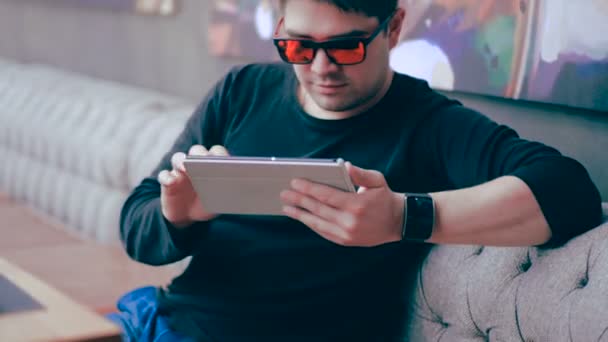 Joven hombre feliz con Tablet PC sentado en la cafetería . — Vídeo de stock