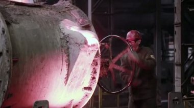 Döküm demir eritme fırınları içinde kontrol işçi.