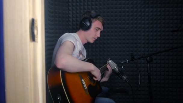 Man spelar gitarr, spelar in en låt i professionell ljudstudio. — Stockvideo