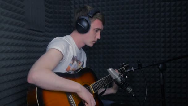 Man spelen gitaar, een lied opnemen in professionele geluidsstudio. — Stockvideo