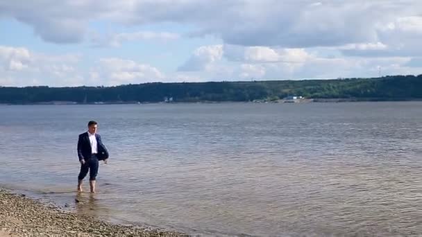 Geschäftsmann, der sich nach einem harten Tag am Strand ausruhen kann. — Stockvideo