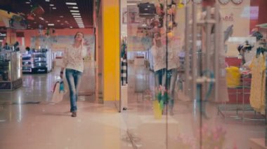 Alışveriş merkezinde mutlu alışveriş kadın smartphone üzerinde söz.