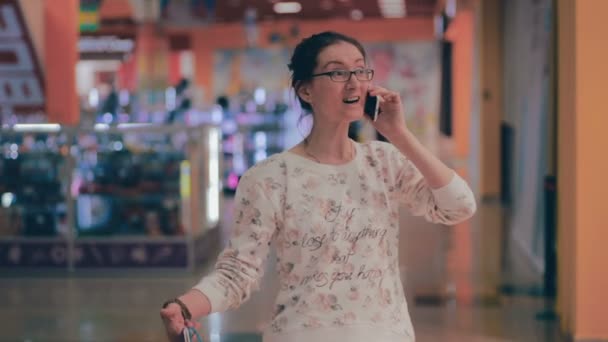 Mulher de compras feliz no centro comercial, falando no smartphone . — Vídeo de Stock