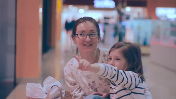Madre e hija comprando, caminando en el centro comercial, mirando el escaparate . — Vídeos de Stock